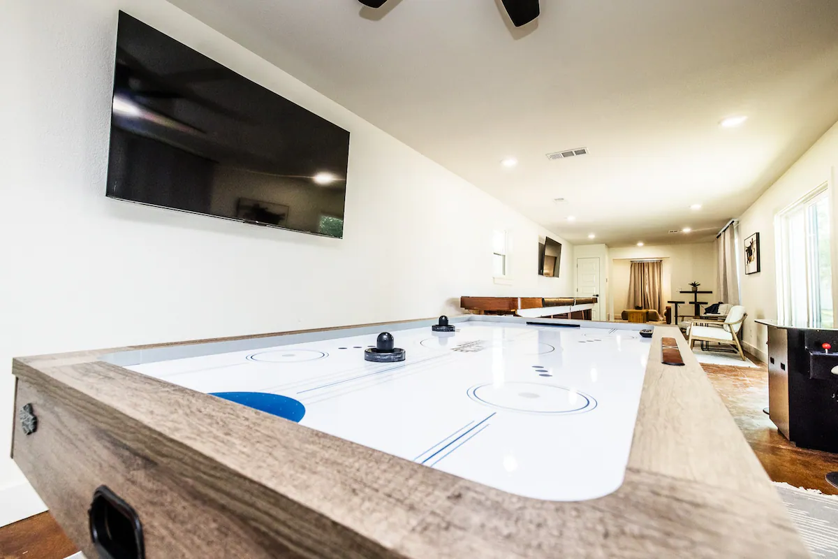 Sandy Shores Oasis air hockey in a game room with television